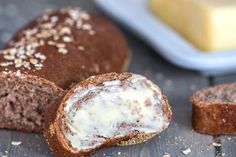 two pieces of bread sitting on top of a wooden table next to a container of butter