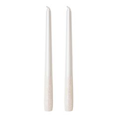 two white candles sitting next to each other