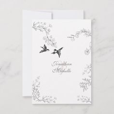 two birds flying in the air on top of a white card with silver foil lettering