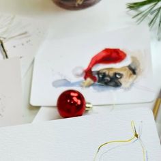 a close up of a christmas card with a dog wearing a santa hat on it