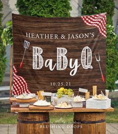 an outdoor baby shower is set up with food and drinks on the table, along with a sign that says,'father & mason's baby q '