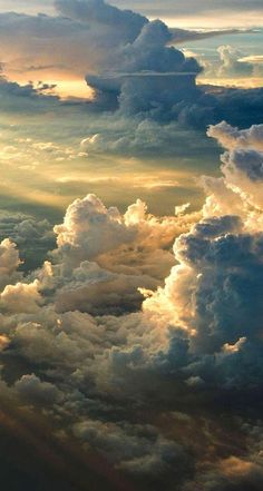 the view from an airplane looking down at clouds in the sky and sunbeams