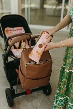 a woman is pulling a stroller with her baby in it and holding the handle