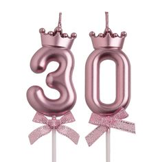 the number 30 is made out of pink foil and sits on top of a stick