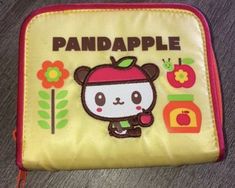 a small yellow bag with an image of a bear and apple on the front side