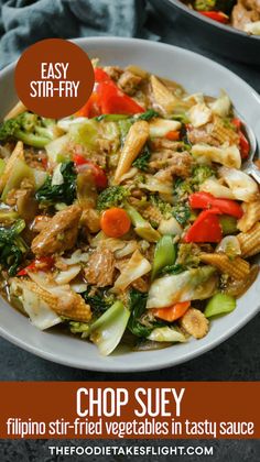 a white bowl filled with stir fry vegetables and meat on top of a black table