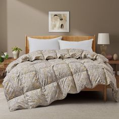 a bedroom with a bed, nightstands and pictures on the wall above it that is decorated in neutral colors