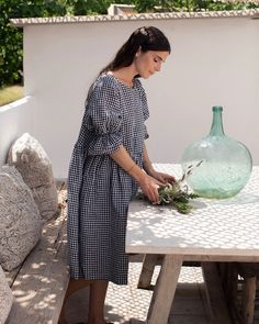 "Voluminous linen dress NERJA in Black gingham is a real eye charmer. Baby doll silhouette and elasticated puffy sleeves instantly transform you into a character from Emily in Paris. With this dress, you can make a statement, and easily adapt it to different styles. Pair it with the ballerinas or high heels for the elegant look or go bold and pair it with some chunky boots and a biker jacket. Details: * Loose fit, baby doll silhouette * Elasticated puffy sleeves * 2 side seam pockets * Medium weight linen (approx. 200 gsm) * The model is wearing a black gingham dress in size M and is 5'11\"(179cm) tall. Model measurements:  Bust: 36'6\"/93cm | Waist: 27'1\"/69cm | Hips: 39'7\"/101 cm * The model is wearing a black dress in size XS/M and is 5'7\" (175 cm) tall. Model measurements: Bust: 35\ Chic Knee-length Gingham Dress, Chic Gingham A-line Dress, Knee-length Gingham Dress For Daywear, Doll Silhouette, Summer Knee-length Gingham Plaid Dress, Summer Dress Linen, Casual Gingham Plaid A-line Dress, Jacket Details, Sage Dress