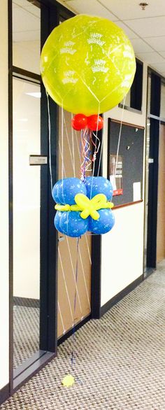 some balloons are floating in the air near an office building door and carpeted floor