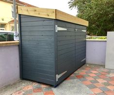 an outdoor storage shed on the side of a building