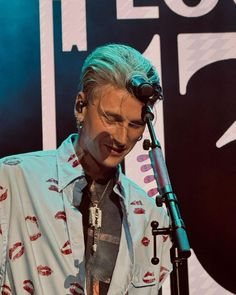 a man with grey hair and piercings holding a microphone