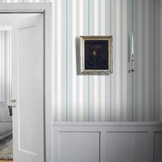 a living room with striped wallpaper and a painting on the wall next to it