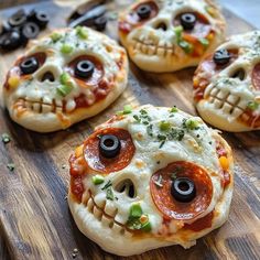 four pizzas with eyes on them sitting on a cutting board