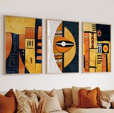 three abstract paintings hang on the wall above a couch in a living room with pillows