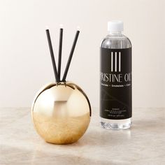 a bottle of perfume next to an apple shaped container with sticks sticking out of it