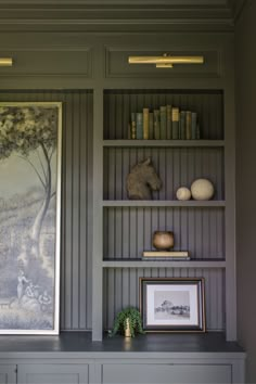 the bookshelves in this room are painted gray and have pictures on them as well