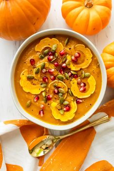 a white bowl filled with pumpkin ginger bisque and topped with pomegranate