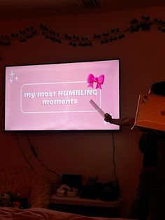 a person standing in front of a projection screen with a pink bow on it's head