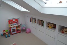 there is a playroom with toys and books on the shelves