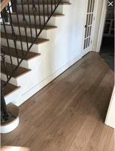 a stair case next to a wooden floor in a house