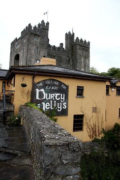 an old castle like building with a sign on the front and side of it that says dury hellys