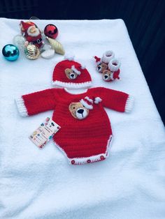 a baby's red and white knitted christmas outfit with teddy bears on it