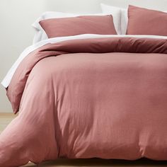 a bed with pink linens and white sheets