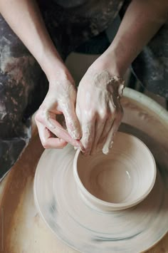 a person is making something out of clay on a potter's wheel