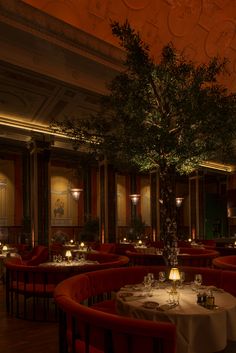 an empty restaurant with tables and chairs, lit up by candlelightes on the ceiling