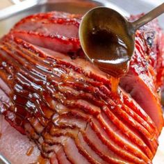 sliced ham with sauce being drizzled onto it