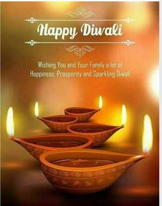 happy diwali greeting card with three bowls and lit candles on the table in front of