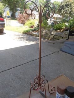 a metal weathervane sitting on top of a wooden table next to a sidewalk