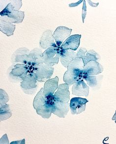 watercolor painting of blue flowers on white paper