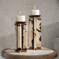 two white candles sitting on top of a table