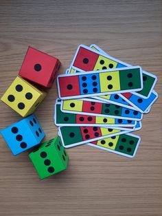 several colorful dices sitting next to each other on top of a wooden table with black dots