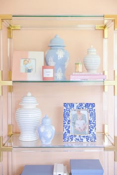 the shelves are filled with vases, books and other decorative items in blue and white