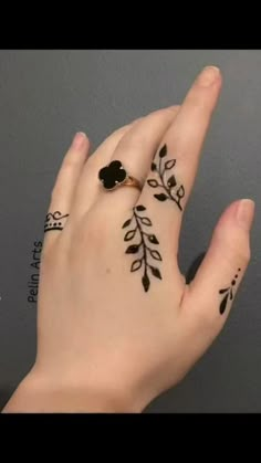 a woman's hand with henna tattoos on it