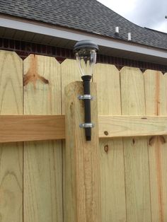 a light on the side of a wooden fence