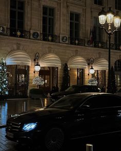 a car parked in front of a building with christmas lights on it's windows