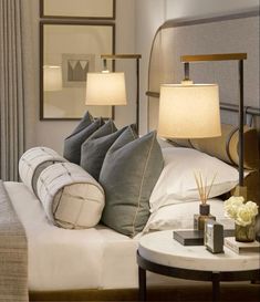 a bed with pillows and lamps on top of it