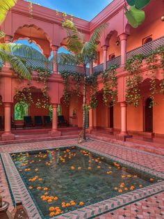 an indoor courtyard with oranges in the water