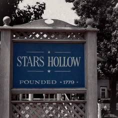 a blue sign that says stars hollow is located in front of a fence and trees