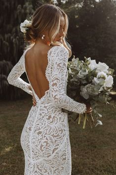 the back of a woman's wedding dress, with flowers in her hair and bouquet