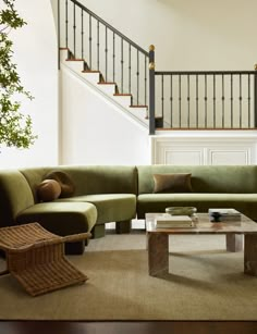 a living room filled with furniture and a stair case in front of the couches