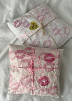 two pillows are wrapped in pink paper and tied with twine