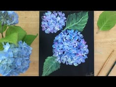 two pictures of blue flowers and green leaves on a wooden table with paintbrushes