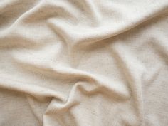 an unmade bed with white sheets and pillows