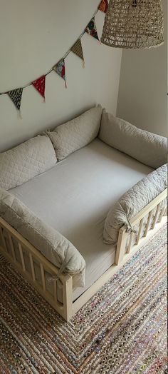 a day bed with pillows on it in a room next to a lamp and rug