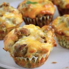 a white plate topped with muffins covered in cheese and meat topping on top of each other