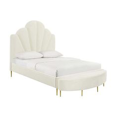 a white bed with gold legs and an upholstered headboard on the side